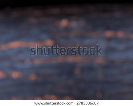Soft defocused abstract background of charred tree bark with glowing orange cracks and dark blue tones. Bokeh texture for grunge, dark, or fire damage backdrop concept
