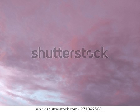 Soft, diffused clouds creating a beautiful, subtle gradient of dusty rose, mauve, and pale pink across the sky. Excellent atmospheric background or copy space.