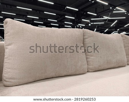 Soft divan with large throw pillows, perfect for any living room, available in the furniture department