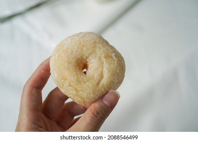 Soft Donut With Japanese Style. Hand Holding A Donut With Soft And Fluffy Texture, Topped With Icing Sugar. White Background.