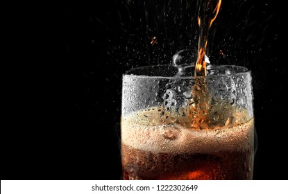 Soft Drink Glass With Ice Splash On Dark Background.