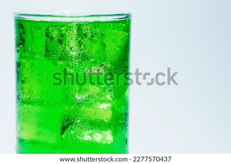 Soft drink, green water in glass and has a white background