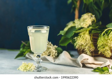 Soft drink with ice cubes from elderflower syrup, juice or champagne in a glass on a light gray table surface, selected focus, narrow depth of field - Powered by Shutterstock