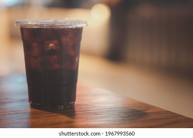 Soft Drink With Ice In Takeaway Cup On Wood Table