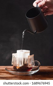 Soft Drink : A Mug Of Coffee / A Hand With Black Dripping Pot Pouring Boiled Hot Water To Coffee Dripper On Wooden Table And Black Background At Home With Copy Space