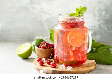 Soft Drinks, Healthy Beverage. Refreshing Summer Glasses Drink Raspberry With Mint Lime And Ice On A Stone Table. Copy Space.