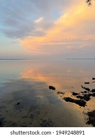 Soft Evening Sunset Clouds Reflecting Across Still Bay Water