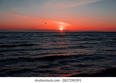 Soft evening waves roll across the Baltic Sea beneath a glowing sunset, creating a timeless seascape filled with warm colours and peaceful atmosphere.