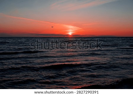 Soft evening waves roll across the Baltic Sea beneath a glowing sunset, creating a timeless seascape filled with warm colours and peaceful atmosphere.