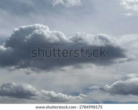 Soft fluffy white clouds floating across vivid blue sky in peaceful natural daytime atmospheric cloudscape