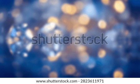 Soft focus abstract background with shimmering blue and gold bokeh lights and a hint of diamond sparkle effect.