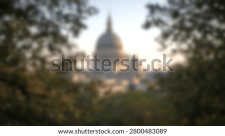 Soft focus abstract view of the iconic US Capitol dome in Washington DC framed by lush green foliage during golden hour