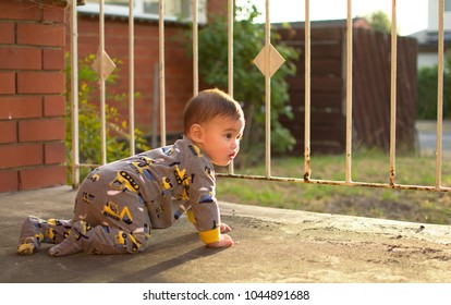 Soft focus baby crawling on the balcony looking at tho road waiting for someone