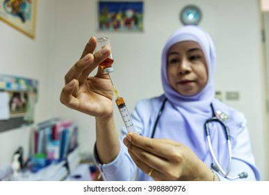 Soft focus and background blur islamic nurse preparing injection.