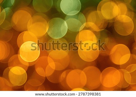 A soft focus background featuring numerous out-of-focus circular lights in warm shades of orange, yellow, and green, creating a dreamy and festive atmosphere.
