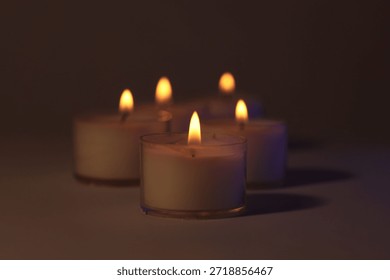 Soft focus. blur Burning candles in dark. Evening, night Light and shadow brown background. Minimalist still life.