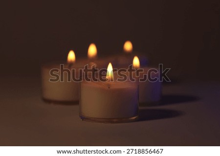 Soft focus. blur Burning candles in dark. Evening, night Light and shadow brown background. Minimalist still life.