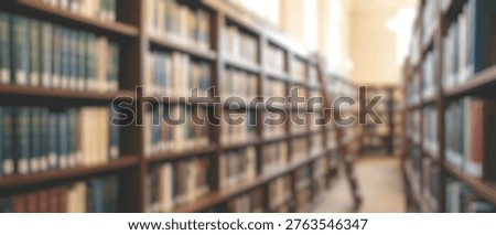 A soft focus, blurred background image of a library interior, showcasing rows of bookshelves filled with numerous books under warm, inviting light.