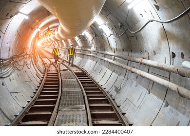 Soft focus and blurred lighting background of focus at railway.Engineer or technician control. Underground tunnel infrastructure. Transport pipeline by Tunnel Boring Machine for electric train subway.