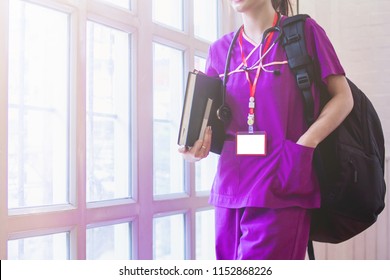 Soft Focus And Blur,The Medical Student Wearing A Purple Uniform Is Walking Through A Window In The Nursing College Building In The Morning To Attend A Black Backpack Classroom And Hold A Textbook.