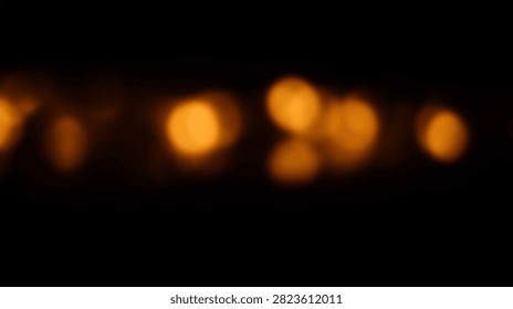 Soft focus bokeh lights create a warm and inviting abstract background with a gentle orange glow against a dark backdrop.