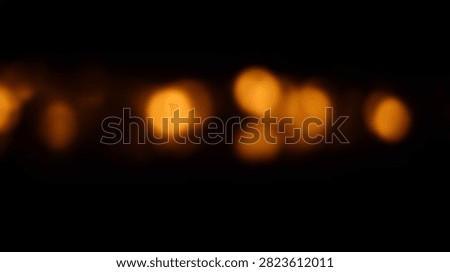 Soft focus bokeh lights create a warm and inviting abstract background with a gentle orange glow against a dark backdrop.