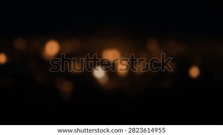 Soft focus bokeh lights create a warm and inviting abstract background with a dark, moody atmosphere.