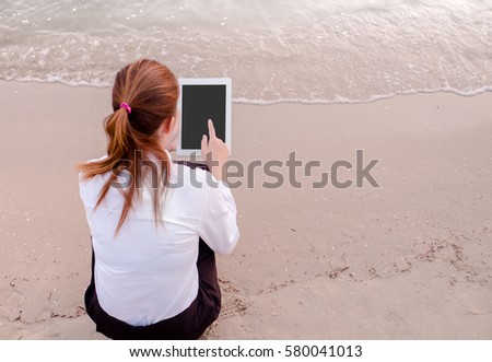 soft focus business woman relaxing working Using tablet and Toe Foot touches the sea on the beach At the time of sunset . happy at work Concept .