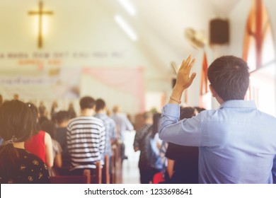Soft focus of Christian worship with raised hand at church