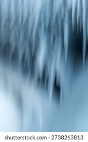 Soft focus close up of icicles inside a natural ice cave on frozen Lake Baikal, Siberia. Shallow depth of field creates a dreamy blurred effect with blue icy tones and smooth bokeh.