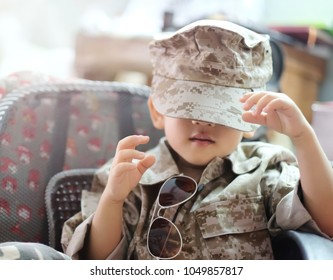Soft focus and closeup at Asian kid wearing soldier suit and try to wearing a hat. / The handsome boy wear military uniform / concept of dream, future, culture and indoctrination. - Shutterstock ID 1049857817