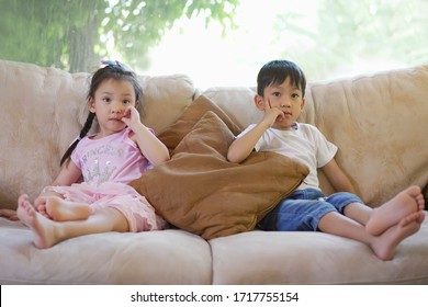 Soft Focus At Cute Asian Siblings Sit At Living Room. Kids Watching Tv And Relaxing At Home, Cute Asian Kids Stay At Home, Concept End Of Semester, Term Ending, School Holidays , Homely Weekend. 