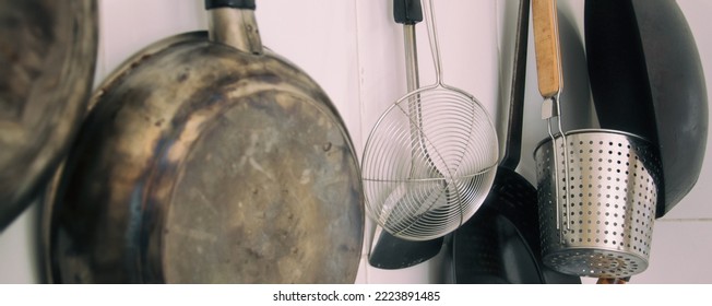 Soft Focus Detail Of Pans And Kitchen Utensils Sitting On The Kitchen Wall