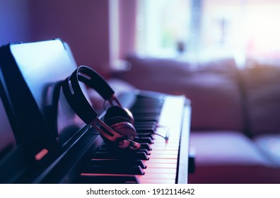 Soft Focus Digital Piano Keyboard With Modern Headphones For Music With Blurry Of Sofa Background, Cosy Cinematic Scene Of Relaxing In Living Room With Morning Light Shining Through Window