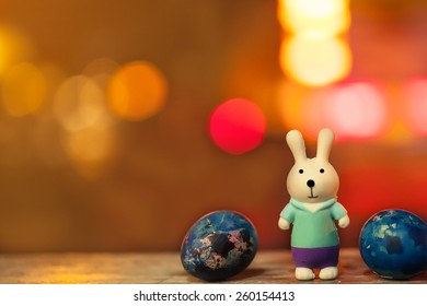 soft focus of easter decorate with rabbit toy and easter eggs on night light bokeh background. vintage color tone.
