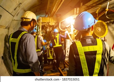 soft focus Engineers wear helmet vests safety  Technician control underground tunnel construction at working shaft to maintenance Transport pipeline by Tunnel Boring Machine(TBM) method for train 