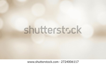 A soft focus image featuring white and beige bokeh lights scattered across a cream-colored background, creating a dreamy and ethereal atmosphere with a mix of light and shadow