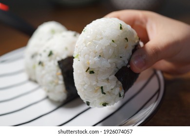 Soft Focus Image Of A Kid's Hand Holding A Japanese Rice Ball 