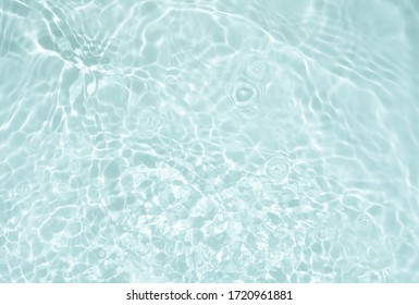 Soft focus lite green blue gray cosmetic moisturizer floral water, micellar toner, or emulsion abstract background. Reflections of  scattered sun texture.