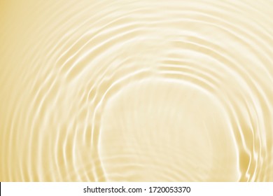 Soft focus lite yellow cosmetic moisturizer floral water, micellar toner, or emulsion abstract background. Reflections of  scattered sun texture.