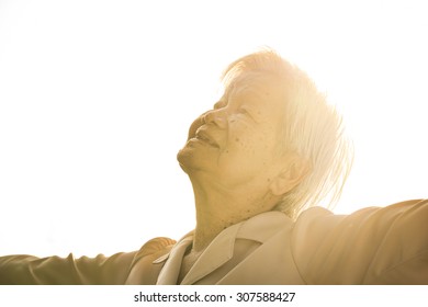 Soft Focus Of An Old Asian Woman Feel Happiness Under Sun Light In The Evening