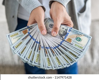 Soft focus on woman hands proposing money us dollar bills to you.