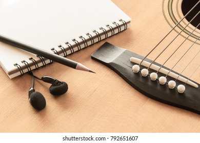 Soft Focus Of Pencil Blank Notebook And Earphone On Acoustic Guitar In Vintage Tone With Copy Space.