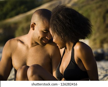 Soft focus portrait of a loving African American couple sitting on the beach