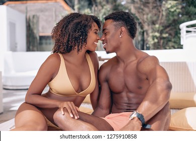 Soft focus portrait of a loving African American couple sitting near the swimming pool and kissing. Phuket. Thailand. Trip to warm destination - Powered by Shutterstock