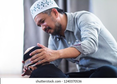 Soft Focus Of Religious 40s Asian Muslim Man Teaching His Little 2 Years Old Son To Pray To God At Home.They Were Wearing Prayer Cap.Peaceful And Marvelous Warm Climate.Selective Focus