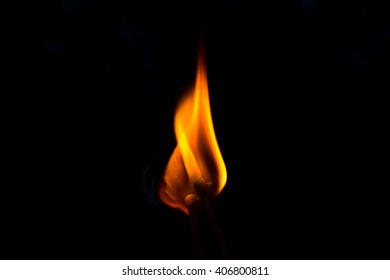 Soft focus and selective focus of a burning match, isolated in dark room