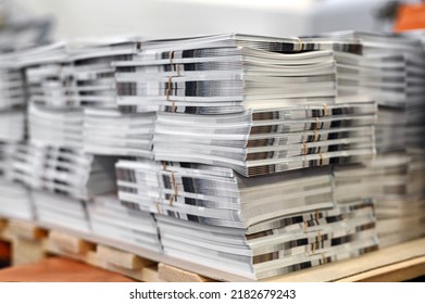 Soft focus of sheets of freshly printed catalogs stacked together on wooden pallet in typography workshop - Shutterstock ID 2182679243