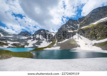 Soft focus. Super wide angle shot. Mountain peaks covered with snow. Lakes with clear blue water.