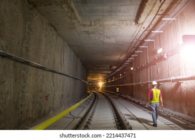 Soft Focus Of Tunnel. Engineers Wear Helmet, Vests Safety .Technician Control Underground Construction At Working Shaft To Maintenance. Transport Pipeline By Tunnel Boring Machine Method For Train.